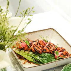 Our Korean BBQ chicken is grilled to perfection and served on a bed of greens. The char marks add a smoky flavor that pairs beautifully with the sweet and savory marinade.