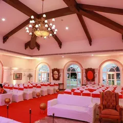 The indoor seating arrangement for the 'MAISHA' reception. The hall's grand architecture with high ceilings and chandeliers was complemented by our choice of red and white themed seating.