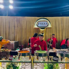 Our live Thai food station, where chefs serve a variety of authentic curries, including classic green and red curries. The elegant gold and glass counter adds a touch of sophistication.