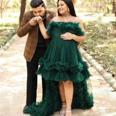 An outdoor maternity photoshoot is perfect for capturing love in a natural, romantic setting. Here, a gentle kiss on the hand in a beautiful park setting tells a story of love and anticipation.