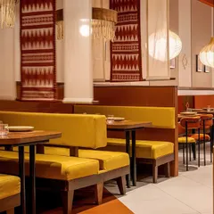 The seating at Tres Amigos is a mix of cozy booths and flexible tables. We used earthy yellow upholstery for the benches and custom-designed textile scrolls as partitions, creating a sense of intimacy while maintaining the restaurant's lively, communal feel.