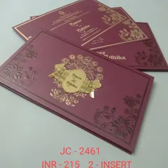 A beautiful magenta invitation with embossed floral details and a central gold nameplate. The rich color and intricate design make it a luxurious choice.