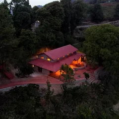 The Sargakhet Handicraft Centre, once a dilapidated British-era post office, is now a warm, inviting hub for local artisans, seen here glowing at dusk in the Mukteshwar valley.