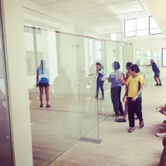 A view from outside the glass-back court, showing our coaches and players during a busy Monday session. We are always present and engaged, guiding our athletes through every drill.