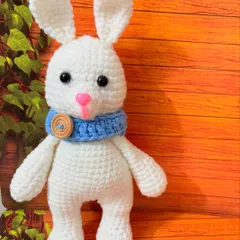 An adorable 8-inch white bunny with a cozy blue scarf. This little friend is made with pure cotton yarn and is super soft to the touch.