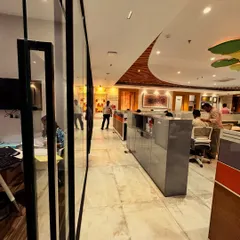 This angle captures the flow and movement within the office. The marble flooring and strategic lighting guide you through the space, leading past the private cabins and towards the collaborative work zones, all under the canopy of the symbolic tree.