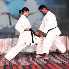 As a master, I personally guide my students to perfect their power. Here, I assist a female black belt in focusing her energy for a successful knee strike, a vital technique in close-quarters self-defense.