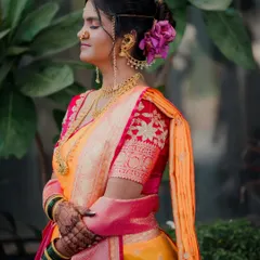 I love capturing the serene moments before the ceremonies begin. Here, the bride takes a peaceful second to herself, her traditional Maharashtrian attire, complete with a Nauvari saree and floral hair accessories, glowing in the soft light.