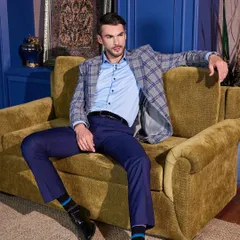 A grey and blue plaid sports jacket paired with navy trousers creates a sophisticated, smart-casual look. This is custom tailoring that feels relaxed but looks sharp, perfect for a business lunch or creative workplace.