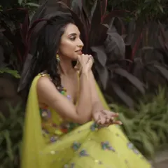 A side profile of the mehendi look, showing the playful hairstyle and the radiant makeup that enhances her natural beauty.