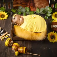 Our little honey bee. This newborn is peacefully sleeping in a "House of Honey Bee" setup, surrounded by sunflowers, honey pots, and tiny bee props.