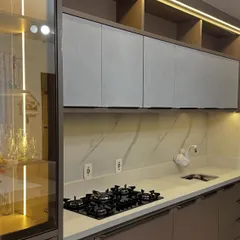 A close-up of a modern kitchen featuring a glass-fronted crockery cabinet with warm LED lighting. I also included open shelving above for displaying decorative items.