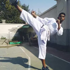 A young student executes a clean side kick with excellent form and focus. Mastering the basics is the first step toward becoming a great martial artist.