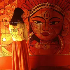 My art meets traditional art. Here I am in my hand-painted Durga jacket, standing before a magnificent Durga mural. It’s a beautiful moment of connection between my wearable art and larger-than-life festive decorations.