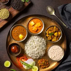 A complete North Indian vegetarian thali for Chhappan Bhog. This overhead shot is composed to display the variety of dishes, including paneer curry, dal makhani, and jeera rice, for menu and advertising use.