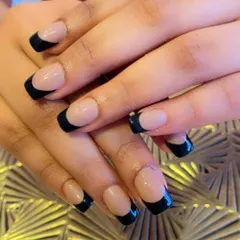 A minimalist and modern take on the French manicure. These square-shaped nails feature a nude base with a very thin, crisp black line at the tips.