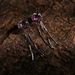 The rich texture of the wood bark provides a beautiful, earthy contrast to the polished silver and vibrant purple stones of these earrings, a key technique in our nature-inspired product photography.