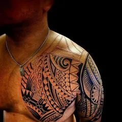 A close-up of a Polynesian tattoo, showing the detailed line work and shading on the shoulder and chest. Each section has a unique pattern that connects to the overall design.