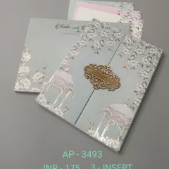 A lovely gate-fold invitation in a soft mint green, featuring white floral prints and silver foil accents. An ornate wooden clasp holds the card together, revealing three inserts inside.