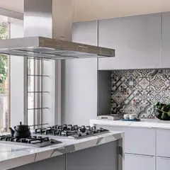 A closer look at the kitchen, where the patterned backsplash adds a touch of traditional charm to the modern, sleek cabinetry. The view to the outside greenery remains a key feature of the space.