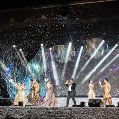 The grand finale of a performance on our iridescent Sangeet stage. The combination of spotlights, confetti, and the shimmering, textured stage creates a celebratory and visually spectacular moment.