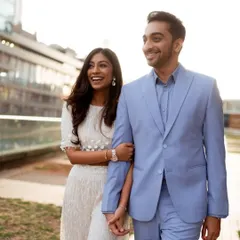 A happy, candid moment of the couple strolling through a modern urban space in Mumbai. Their genuine smiles and relaxed posture show the comfortable and joyful nature of their relationship.