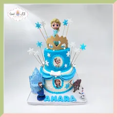 This enchanting Frozen-themed cake is a winter wonderland. It features Elsa and Anna, a sparkling ice castle candle, and snowflake details, making it a magical centerpiece for a princess party.