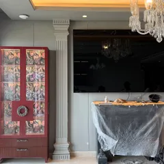 The 'before' shot of a luxury living room project. This image captures the space during the renovation process, with the custom red display cabinet and classical pillar already in place, hinting at the grand design to come.