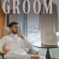 The groom, Chahat, in a moment of quiet contemplation. This stylish portrait captures his modern yet traditional look, with his sherwani hanging in the background.