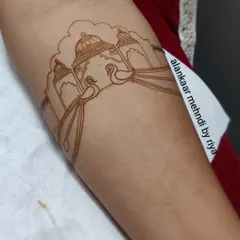 The first step of a royal bridal design: the outline. Here, the basic structure of a palace and peacock motif is carefully drawn.