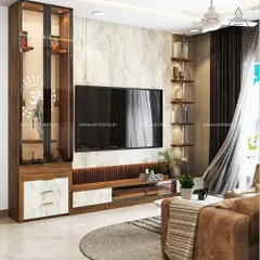 This living room features a tall, elegant pooja unit with a glass door and an Om symbol, seamlessly integrated next to the modern TV console.