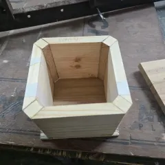 An inside look at the construction of a mitered box, showing the clean, angled joints held together with tape during the glue-up process.