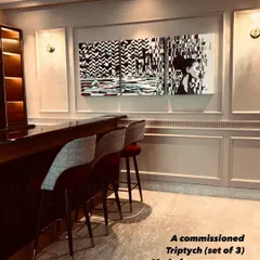 This set of three paintings uses a black and white palette with sharp, glitch-like geometric patterns to create a cohesive and dramatic art feature above a home bar.