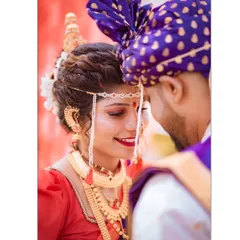 An intimate close-up of a Maharashtrian bride and groom. The bride's beautiful smile and the traditional mundavalya create a classic and emotional wedding portrait.