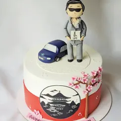 This farewell cake for a CFO is a perfect example of detailed storytelling. It includes a figurine holding an "I am CFO" sign, a model of his BMW, and a hand-painted scene of Japan to represent his love for the country.