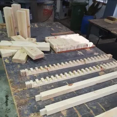 The design is then broken down into individual components. This image shows all the precisely cut pieces for the bench, including the legs, stretchers, and notched seat slats, ready for assembly.