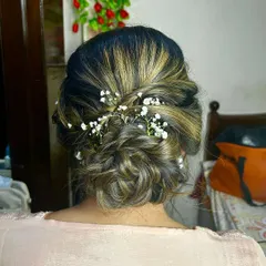 A soft and messy updo with delicate baby's breath woven through. This hairstyle is perfect for a romantic, bohemian-inspired look for any pre-wedding event.