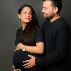 A classic maternity pose, with the couple looking at each other, their hands on the baby bump, sharing a moment of connection.