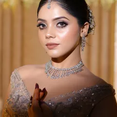 This portrait shows the soft glam makeup from the front. The neutral color palette on the eyes and lips ensures the focus remains on the bride's natural beauty and the sparkling details of her outfit.