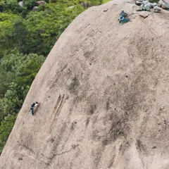 An aerial view of a climber on the 50-meter Gaali Kallu spire. This route has a fascinating story involving local villagers who believe a statue of the bull-god Basava sits on one of its ledges.