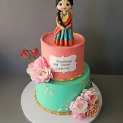All dolled up to celebrate womanhood. This two-tier cake for Anushika's Half Saree ceremony features a beautiful, hand-sculpted figurine in a traditional lehenga.