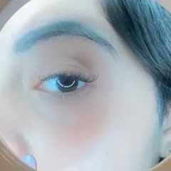 A close up look through a magnifying mirror at a light cat eye wing. This style adds a subtle flick to the outer corner for a flirty, defined look.