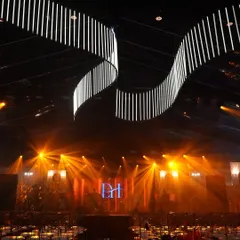 The stage and lighting setup for the Vietnam Sangeet. A custom monogram for the couple and dynamic lighting rigs transformed the space into a professional concert venue for one night.