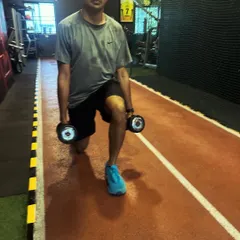 A client performs walking lunges with dumbbells on our indoor track.