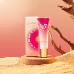 This desert-themed shot for Mars Cosmetics' "Blush Hour" uses sand and driftwood to create a warm, natural environment. The composition highlights the product and its packaging against a soft, gradient sunset background.