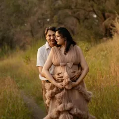 A classic and tender maternity pose, with him holding her and the baby bump from behind. This image beautifully frames their unity and the protective love they already feel for their child.