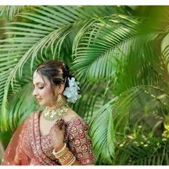 A side profile of the bride, showing the elegant floral hair bun and the subtle contouring that defines her features.