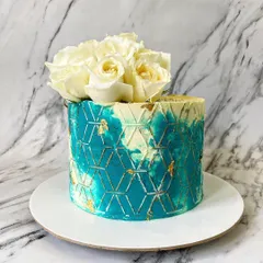 I love working with unique colors like this jade green. Paired with a geometric stencil, gold leaf, and fresh white roses, this design is modern, artistic, and incredibly chic.