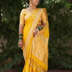 A full-length view of a bride's Haldi look. The yellow silk saree is draped elegantly to allow for movement while maintaining perfect pleats, ideal for ceremony and celebration.