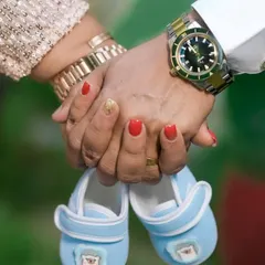 This is a duplicate of image 21. This classic maternity photo, focusing on the couple's hands holding tiny baby shoes, is a beautiful symbol of the new life and love on the way.